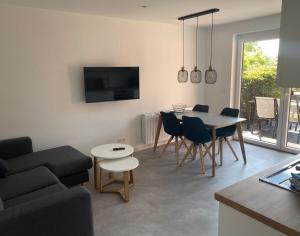 a living room with a couch and a table and chairs at Ferienwohnung Nordwind - Haus Seeschwalbe in Wangerland