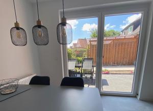 a kitchen with a table and chairs and a sliding glass door at Ferienwohnung Nordwind - Haus Seeschwalbe in Wangerland