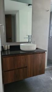un baño con lavabo y espejo en Casa cerca todo en Zapopan !, en Guadalajara 23 fotos más