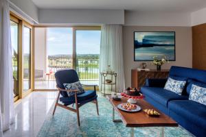 a living room with a blue couch and a table at Victoria Golf Resort and Spa Managed by Accor in Vilamoura