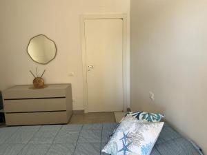 a bedroom with a bed and a mirror and a dresser at Casa Molly in Follonica