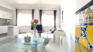 a living room with a glass table with a vase of flowers at Enjoy this apartment, with two bedrooms in Sant Adria de Besos