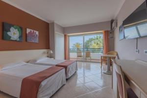 a hotel room with two beds and a balcony at Aldiana Club Rocca Nettuno Calabria in Tropea