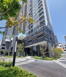 a tall building with a glass facade on a street at Lisa house&home #nearcentralfestival in Ban Kohong