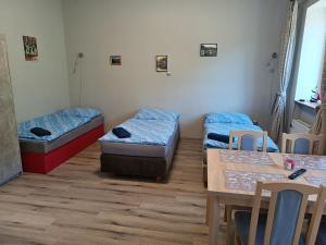 a room with three beds and a table and chairs at Dolní Žleb 124 in Děčín