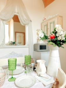 a table with a white vase with flowers on it at Spello House Dormio in Spello