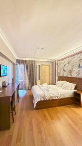 una camera da letto con un letto grande e una scrivania di Emsa Otel Maltepedeki Eviniz a Istanbul