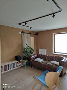 un soggiorno con divano in pelle marrone e finestra di Luxury eco home with large garden and lots of light a Ons Belang