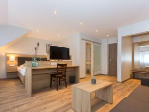 a living room with a desk and a television at Appartements 'In Vino Veritas' in Haslach im Kinzigtal