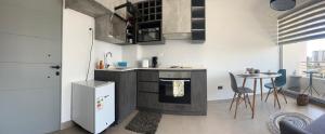 a kitchen with a stove and a table in it at MAIPU CENTRO LADO UNIVERSIDAD udd in Concepción