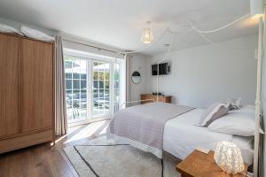 a bedroom with a bed and a large window at Felin Traeth Cottage in Rhosneigr