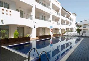 a hotel with a swimming pool in front of a building at Aparthotel Puerto Mar in Peniscola