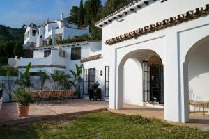 a white house with a patio with tables and chairs at Casa El Cholo, Mijas Hideaway in Mijas
