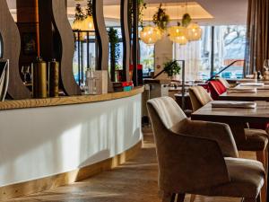 a restaurant with a bar with chairs and tables at Rivage Hôtel & Spa Annecy in Annecy