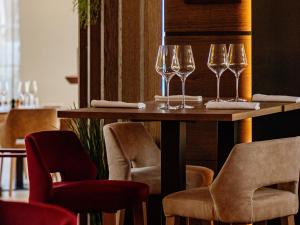a table with wine glasses on it with chairs at Rivage Hôtel & Spa Annecy in Annecy