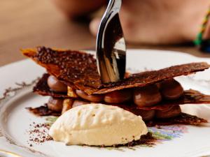 a person cutting up a stack of waffles with a knife at Rivage Hôtel & Spa Annecy in Annecy
