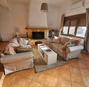 a living room with two couches and a fireplace at KlaireyBelles in Dáfia