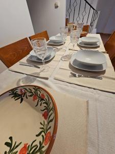 a table with plates and wine glasses on it at KlaireyBelles in Dáfia