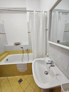 a bathroom with a sink and a bath tub at KlaireyBelles in Dáfia +23 photos