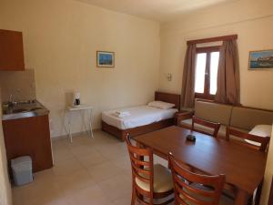 a room with a table and a bed and a kitchen at Evita Studios and Apartments in Bali
