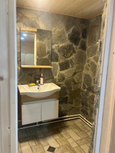 a bathroom with a sink and a stone wall at Sesili Guesthouse in Adishi