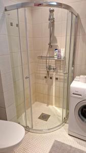 a shower in a bathroom with a washing machine at Peresõbralik korter Kuressaare kesklinnas in Kuressaare