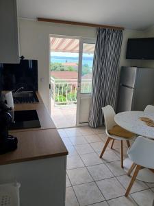 a kitchen with a table and a view of the ocean at Apartmani Fani 2 min walking from sea in Orebić