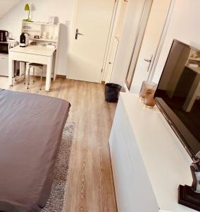 a bedroom with a bed and a desk with a tv at Casa Romano in Lüneburg