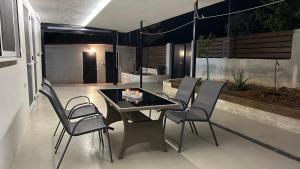 a patio with a table and chairs on a patio at Villa ADAM in Artemida