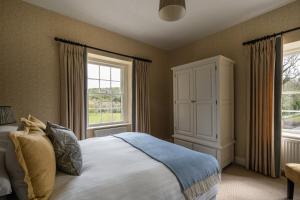 una camera con un grande letto e due finestre di Keeper's Cottage a Glenarm
