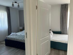 an open door to a bedroom with two beds at Cabanuta in Brașov in Braşov