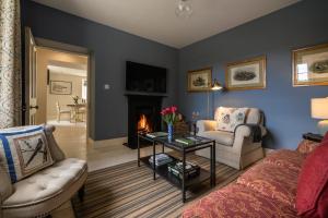 un soggiorno con divano e camino di Keeper's Cottage a Glenarm