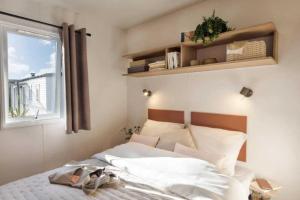 een slaapkamer met een bed en een raam en planken bij Camping 4 étoiles - Piscine - ccb0dhf in Saint-Denis