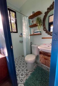 a bathroom with a toilet and a sink and a mirror at Romantic Eco Sanctuary Off-Grid Mountain Retreat in Valencia