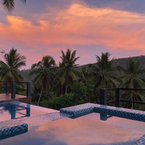 a pool with a view of palm trees at sunset at Romantic Eco Sanctuary Off-Grid Mountain Retreat in Valencia