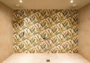 a bathroom with a wall with a floral wallpaper at Hotel Ahornhof in Lindberg +44 photos