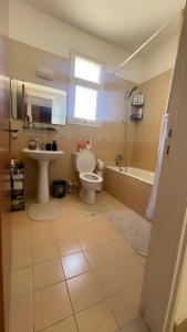 キッソネルガにあるBeautiful & Cozy Apartment in Paphosのトイレ、洗面台、浴槽を備えたバスルーム