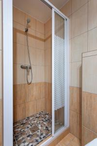 una doccia con una porta in vetro in un bagno di Lucsony Apartman a Mosonmagyaróvár