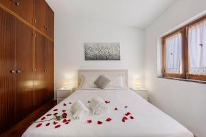 una camera da letto con un letto con rose rosse sopra di Casa Acolhedora a Lagos