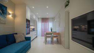 Una sala de estar con un sofá azul y una mesa. en Atlantic Coast 'Princely' Apartment - Playa Del Inglés, en Playa del Inglés