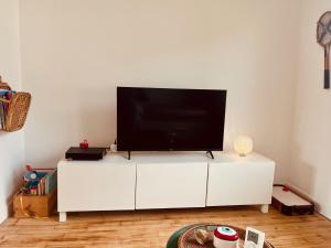 a white entertainment center with a flat screen tv on top at Gigi La Roza in Perros-Guirec +21 photos