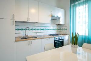 a kitchen with white cabinets and a sink at Casa Vacanze Maiori in Maiori