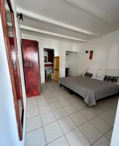 a bedroom with a bed and a tiled floor at VilladesPêcheurs Beach in Cap Skirring