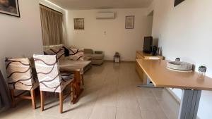 a living room with a table and a couch at Unwind Kìśśornega - 2 Bedroom Apartment in Kissonerga