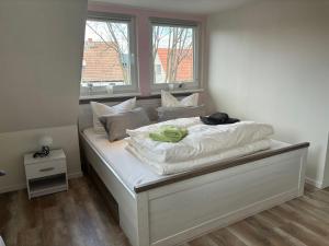 Ferienhaus-Knopp-Ilsenburg في إلسنبرغ: سرير في غرفة بها نافذتين