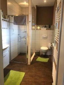 Ferienhaus-Knopp-Ilsenburg في إلسنبرغ: حمام مع دش ومرحاض مع الحصير الخضراء