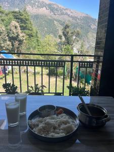 a bowl of rice on a table with a view of a mountain at Secret garden homestay in McLeod Ganj