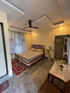a bedroom with a bed and a ceiling fan at Secret garden homestay in McLeod Ganj