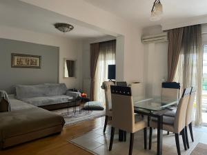 a living room with a table and a couch at Honeybee Apartment kordelio area in Thessaloniki