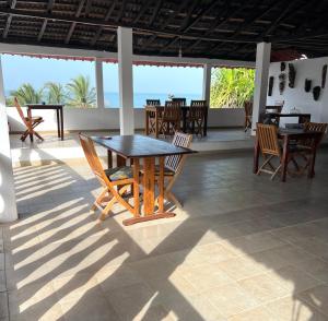 a table and chairs on a patio with a view of the ocean at VilladesPêcheurs Beach in Cap Skirring